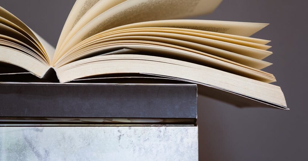 Creative photo of an open book on stacked colorful books, symbolizing learning and literature.